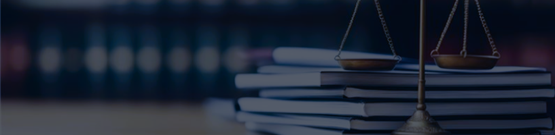 Balance of justice in front of a stack of books