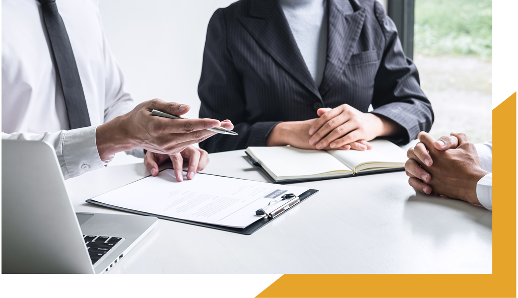 Group of professionals sitting at a desk with notepads
